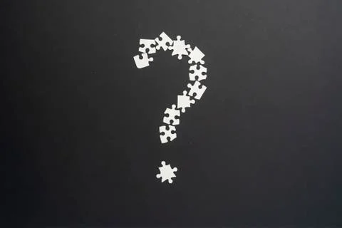 Closeup puzze question mark on dark background isolated Stock Photos