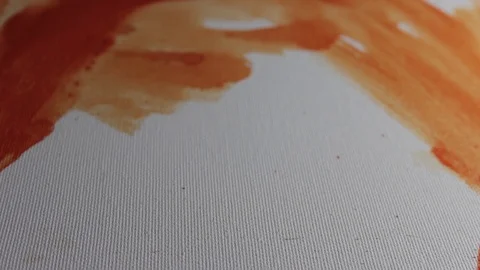 Closeup rack focus shot of orange paint on white canvas Stock Footage 92330340