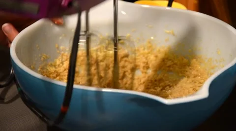 A closeup rack focus shot of a person blending and beating cookie dough Stock Footage