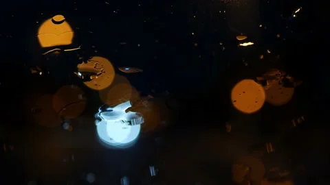 Closeup of rain drops on a windshield at night Video stock 164609369
