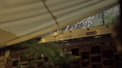 Closeup of Rain Falling From Roof Edge Above Ladder During Night Rainstorm Stock Footage 342236259