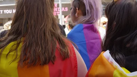 Closeup of rainbow flags being worn in support at a Toronto pride parade - slow Stock Footage 124345480