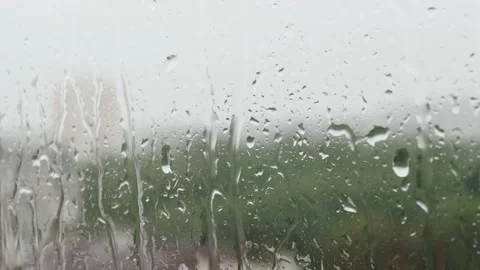 Closeup raindrops water droplets trickling down on wet window glass during heavy Stock Footage 201487541