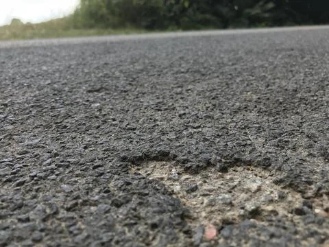 Closeup of a random cordiform heart shape imprint on coarse cemented tar asphalt Stock Photos