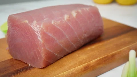 Closeup of raw Tuna Yellowfin on a table with greens and vegetables in 4K. Stock Footage 154334536