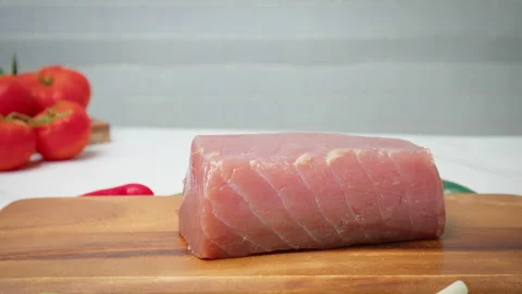 Closeup of raw Tuna Yellowfin on a table with greens and vegetables in 4K. Stock Footage 154334595