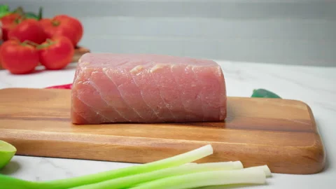 Closeup of raw Tuna Yellowfin on a table with greens and vegetables in 4K. Stock Footage 154334647