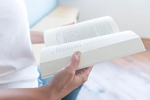 Closeup of a  reader reading a book at home Stock Photos