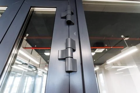 A closeup of a rectangular metal door handle on a building fixture Foto stock