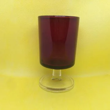 Closeup of a rectangular red drinking glass on a yellow bright background Stock Photos