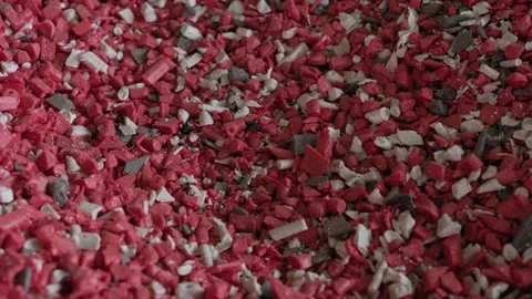 Closeup of red and white shredded recycled plastic granules Stock Footage 337581869