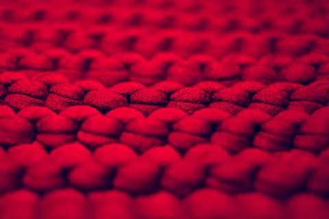 Closeup red background large knitted thread pattern Foto stock