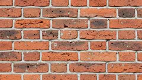 Closeup of a red brick wall with gray mortar Stock Photos