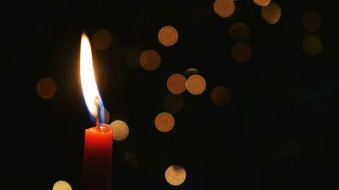 Closeup-Red candle flame dark background blinking bokeh light Stock Footage 71229178