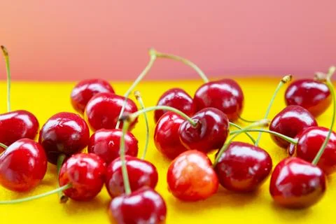 Closeup of red cherries on a yellow table Stock Photos