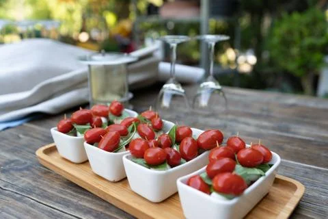 Closeup of red cherry tomatoes with fresh basil and mozzarella cheese. Appeti Stock Photos