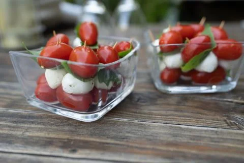 Closeup of red cherry tomatoes with fresh basil and mozzarella cheese. Appeti Stock Photos