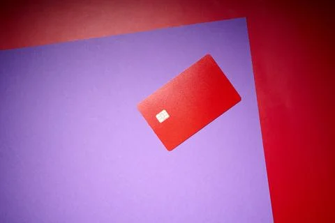 Closeup of a red debit card with a microchip on a purple table Stock Photos