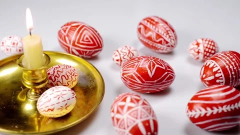 Closeup Red easter eggs with folk pattern lay around and on candlestick Video stock 127888568