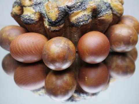 Closeup red eggs with marble pattern and cake on mirror background, copy space Foto stock