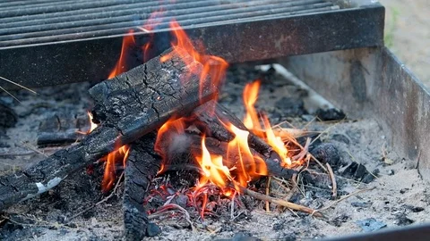 Closeup of red flame in slow motion in fire pit grill in camp site Stock Footage 120608497