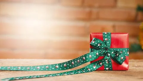Closeup of a red gift box on blurred bricks on background Stock Photos