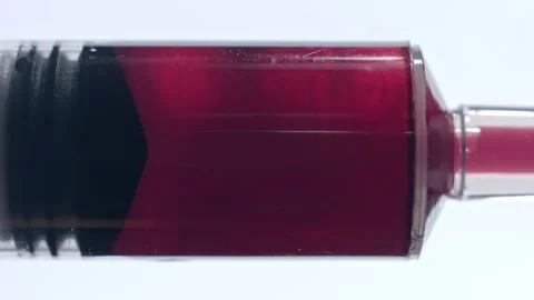 Closeup of red liquid being drawn into and out of syringe vaccine plunger Video stock 146478624