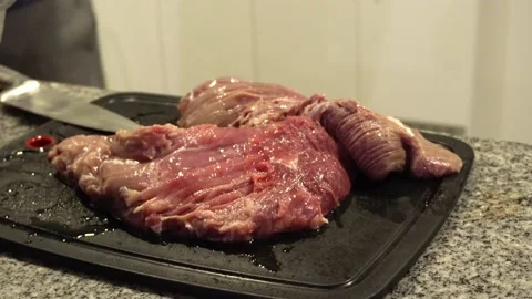 Closeup a red meat on a cutting board and patting it with friends in the kitchen Stock Footage 186219210