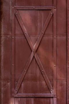 Closeup of a red-painted door with an array of metal bars across its surface 스톡 사진