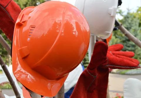 Closeup of a red protective helmet and gloves, outdoor Stock Photos