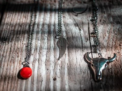 A closeup of red ruby, angel wing, and buffalo skull talismans laid on a wood 写真素材