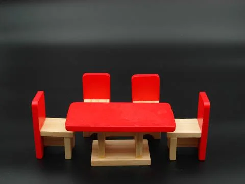 Closeup of a red tiny table and chairs on a black background 写真素材