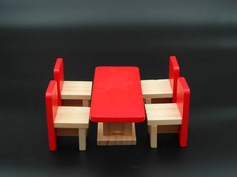 Closeup of a red tiny table and chairs on a black background Stock Photos