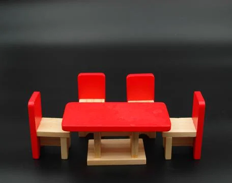 Closeup of a red tiny table and chairs on a black background Foto stock