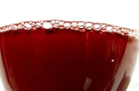 Closeup of red wine bubbles on white background Stock Photos