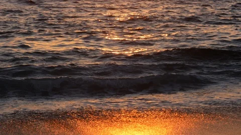 Closeup reflections on waves and wet sand on the beach at sunset Stock Footage 107994872