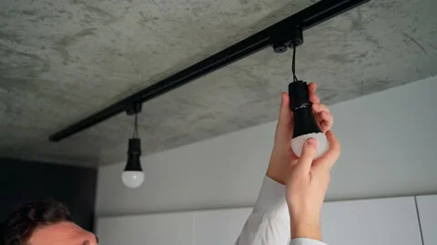 Closeup replacing the old lightbulb with a new energy efficient LED bulb in lamp Stock Footage 153291960