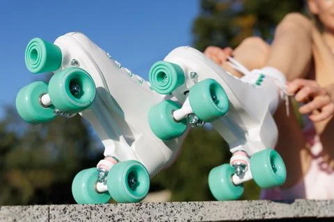 Closeup of retro roller skates with mint wheels outdoors woman lacing footwea Stock Photos