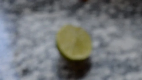 Closeup revealing half of lime lemon tahiti cut in half, over marble sink Stock Footage 114776329