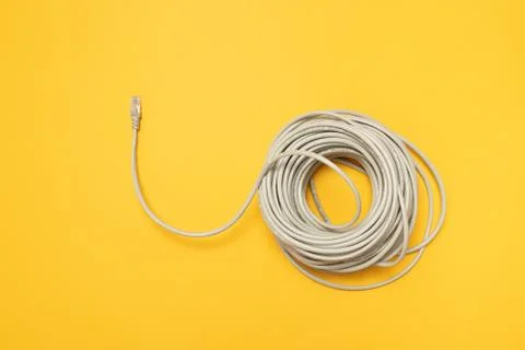 Closeup RJ45 Network internet cable hank on a yellow background. Concept, flat Stock Photos