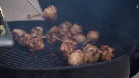 Closeup of roasted chicken legs turned by chef Video stock 218612559