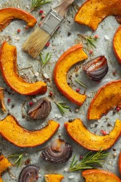 Closeup roasted pumpkin with addition aromatic herbs, red onion, sea salt and Stock Photos