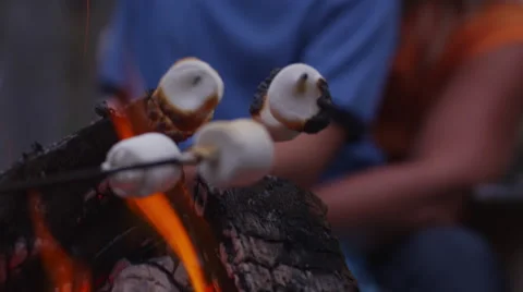 Closeup, roasting marshmallows by outdoor fire. Shot on RED EPIC for high Stock Footage 47384246