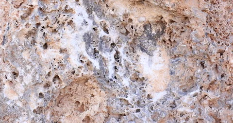 Closeup rock with surface hole texture revealed in slider pullback Stock-Footage 314189639