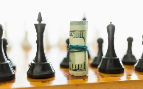 Closeup of rolled dollars on place o black chess piece Stock-Fotos