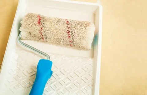 Closeup of roller brush on paint tray Stock Photos