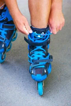 Closeup of roller tying laces on inline roller skates. Foto stock