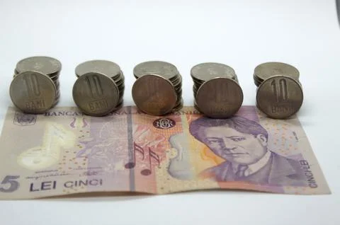 Closeup of Romanian currency stack of 10 bani coins on 5 Lei banknote RON Foto stock
