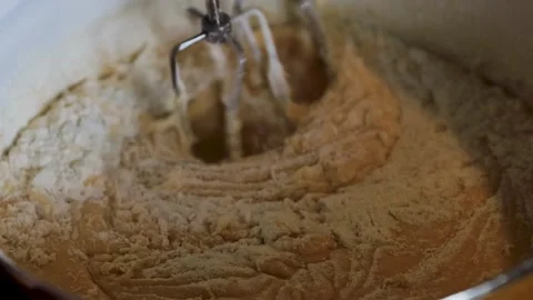 Closeup of rotating electric mixer beaters gradually incorporating dry flou.. Stock Footage 340897407