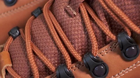 Closeup of rotating pair of fashionable wetherproof leather rufous boots Stock Footage 140467630